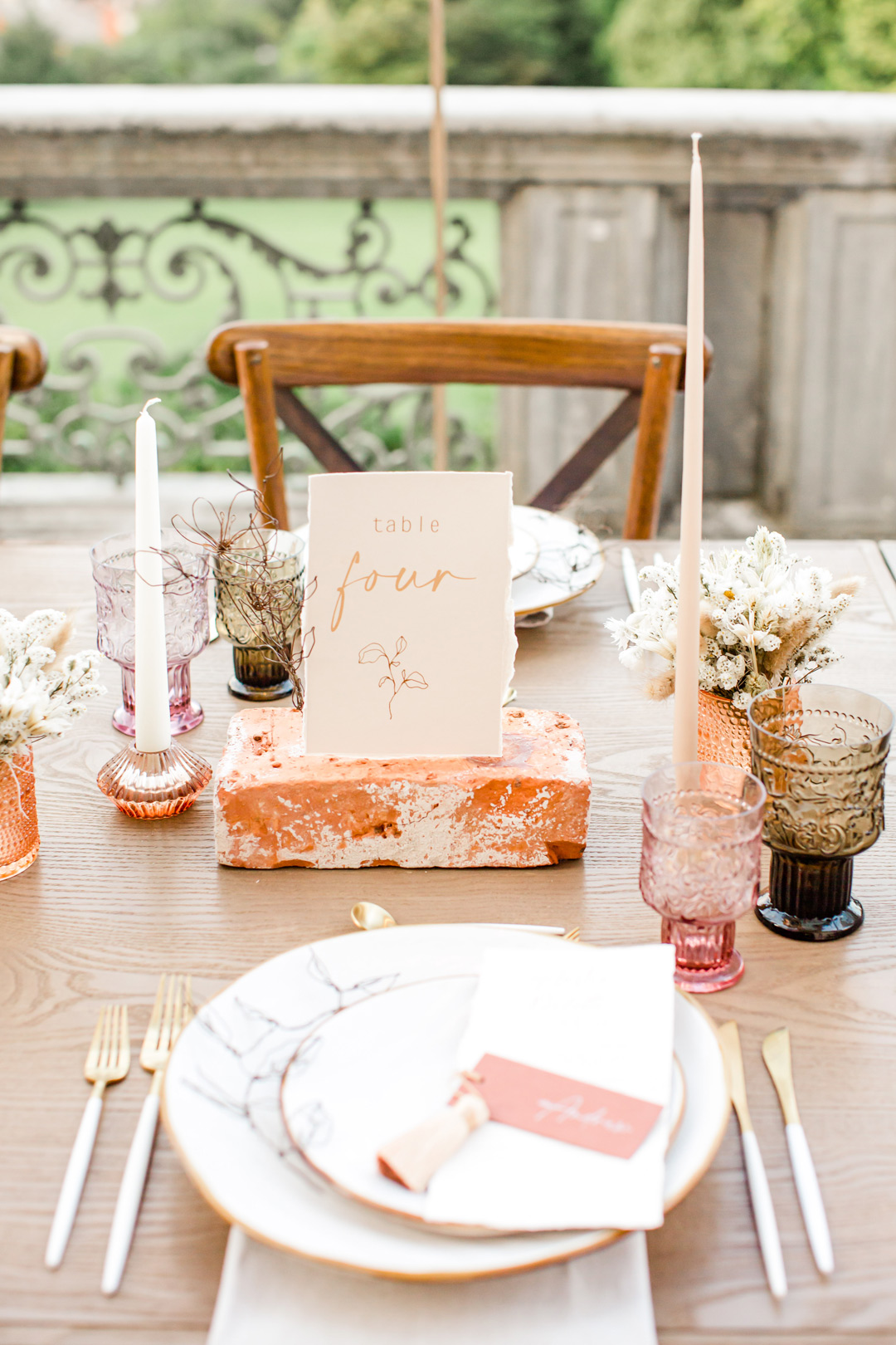 mise en place tavolo con candele, segnaposti e posateria oro e cipria