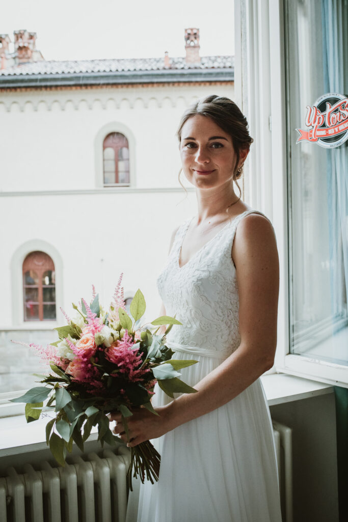 la sposa indossa il suo abito couture e personalizzato e tiene il bouquet prima delle nozze